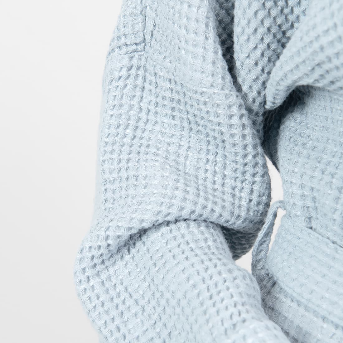 Jasny niebieskawy szlafrok z pranej tkaniny wytkanej splotem waflowym.