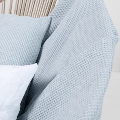 Pled wytkany w melanżu z niebieskawej w szarość i niebieskiej w zieleń przędzy.