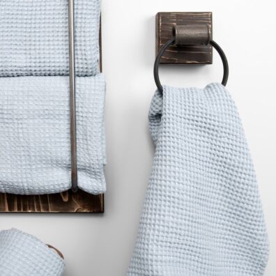 Ręcznik wytkany w melanżu z niebieskawej w szarość i niebieskiej w zieleń przędzy.