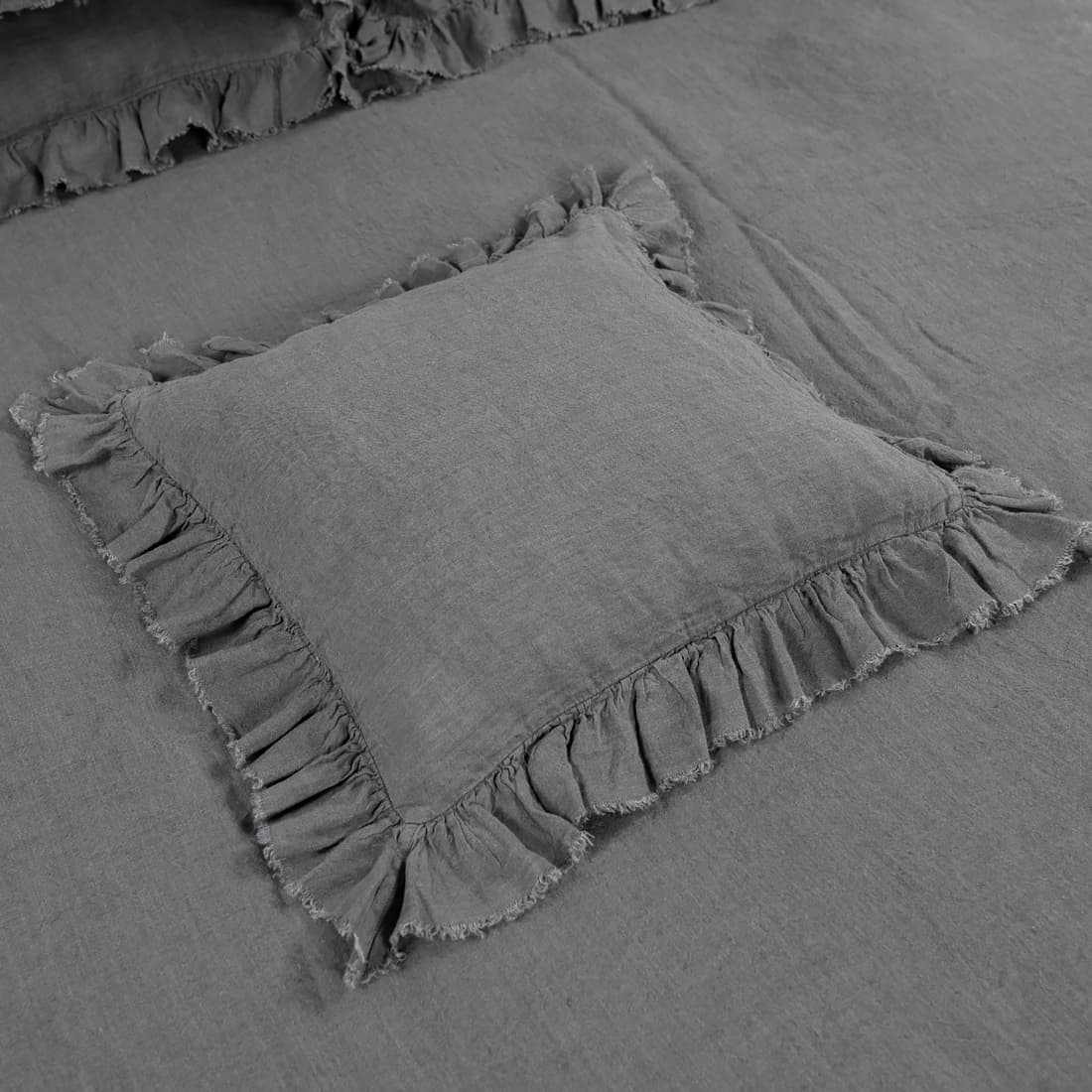 Poszewka na poduszkę ozdobiona na bokach falbanką wykończoną strzępionymi frędzelkmi.