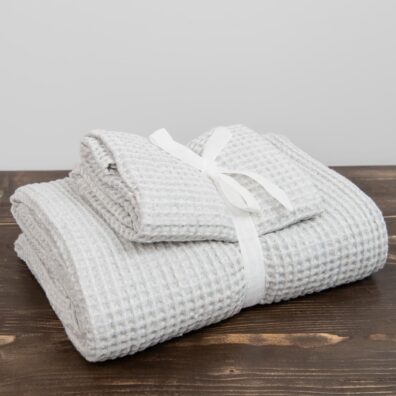 Komplet dwóch ręczników ozdobnie przewiązany wstążeczką.