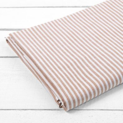 Prześcieradło w brązowe paski zwykle podwinięte.