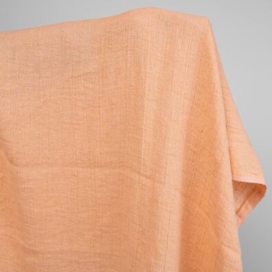 Prana tkanina wytkana w melanżu z brzoskwiniowej i żółtej w brąz przędzy.