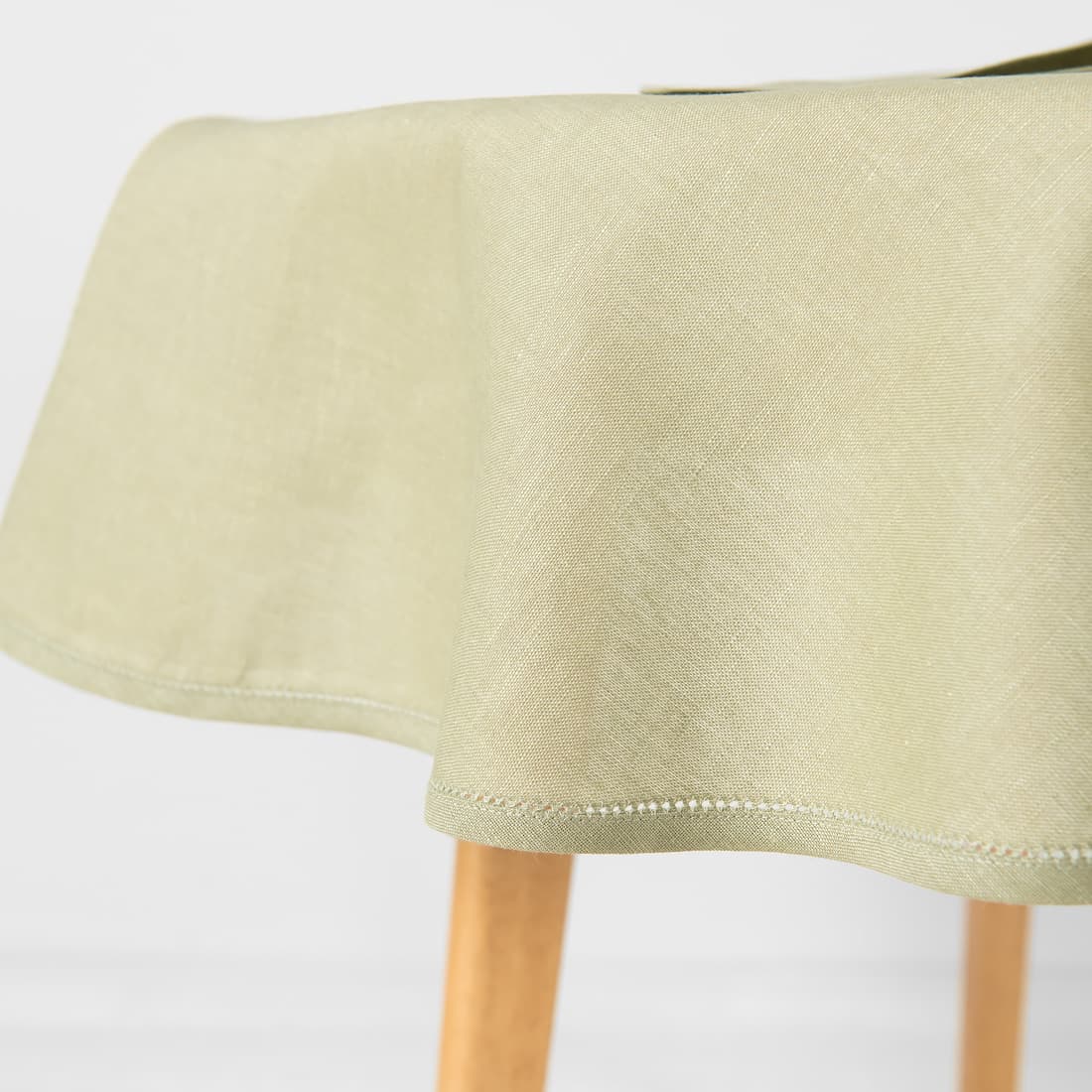 Zielonkawy obrus ozdobiony mereżką