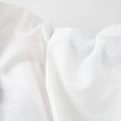 Valkoinen pellavakangas jossa on punaisia kuvioraitoja soveltuu vaatteiden ja kodintekstiilien ompeluun