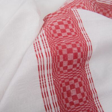 Valkoinen ruudullinen puolipellavainen kangas jossa on punainen raita