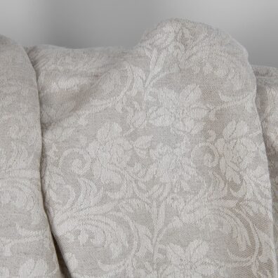 Beige puolipellavainen kangas jacquard jossa on kukkia, valkoinen ja luonnonharmaa (värjäämätön, ruskehtavan harmaa) lanka, jotka on kudottu yhteen