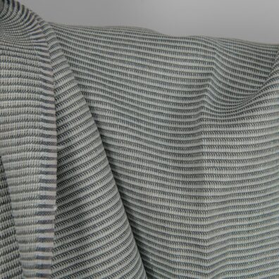 Pellavakangas harmaanvihertävä kuvioitu, mintunvihreää, vaalean sinivihreää, tummansinistä ja vihertävänharmaata lankaa, jotka on kudottu yhteen