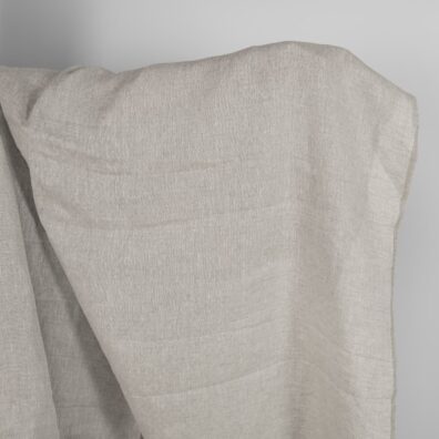 Vaaleanharmaa pellavakangas jossa on ajour-rombeja