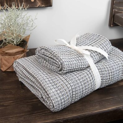 Pellavanharmaa kylpyhuoneen pyyhe mustilla raidoilla, nauhalla sidottu pyyhesetti