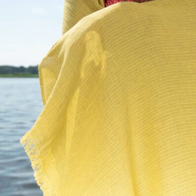 Rantapyyhe, joka on kudottu keltaisella ja vihertävällä melangialla.