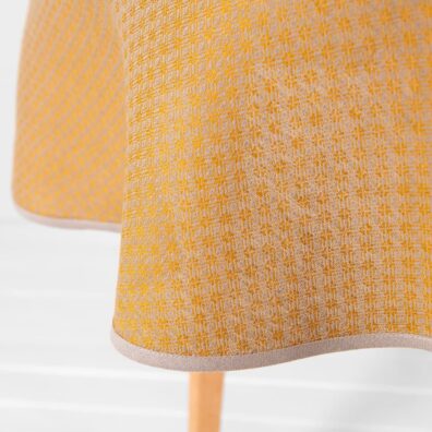 Puolipellava pyöreä ovaali keltainen pöytäliina, 1cm leveä beige piping