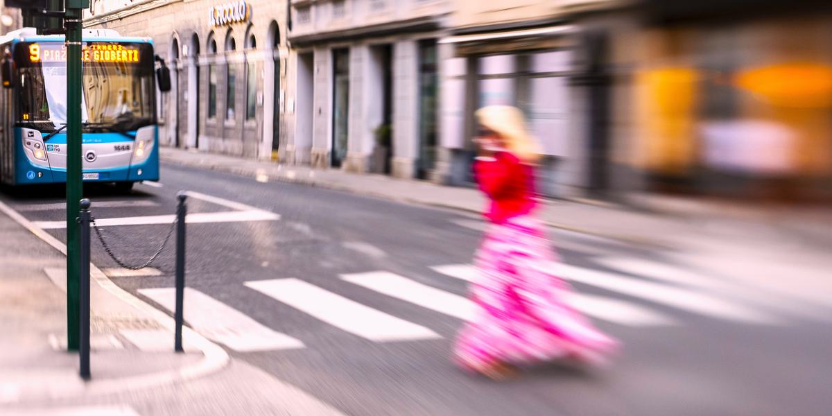 Linea urbana 9 di Trieste, in via Mazzini con una ragazza vestita di rosa che attraversa la strada.
