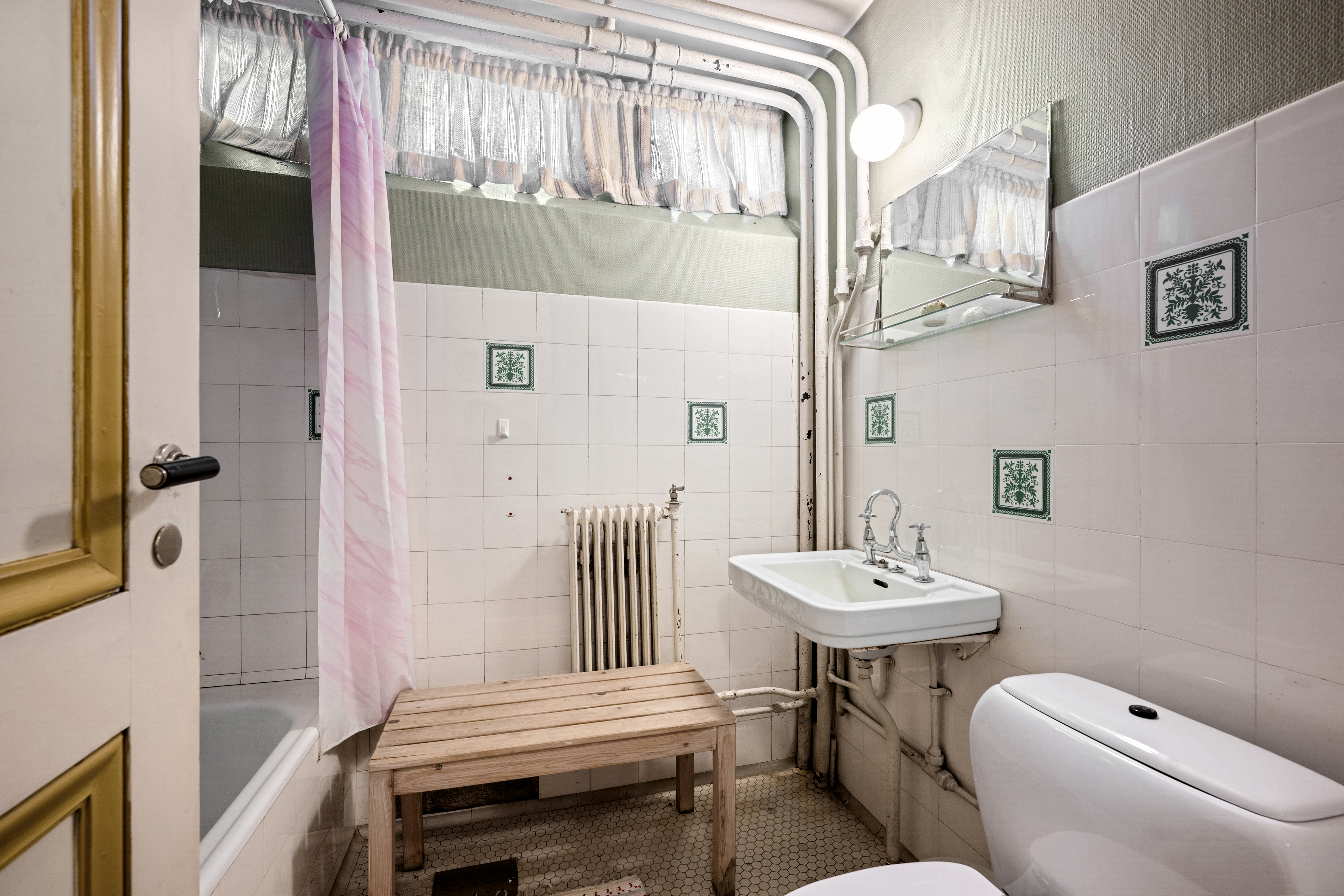 Boligens andre bad ligger i underetasjen og er innredet med badekar, servant, toalett og speil.