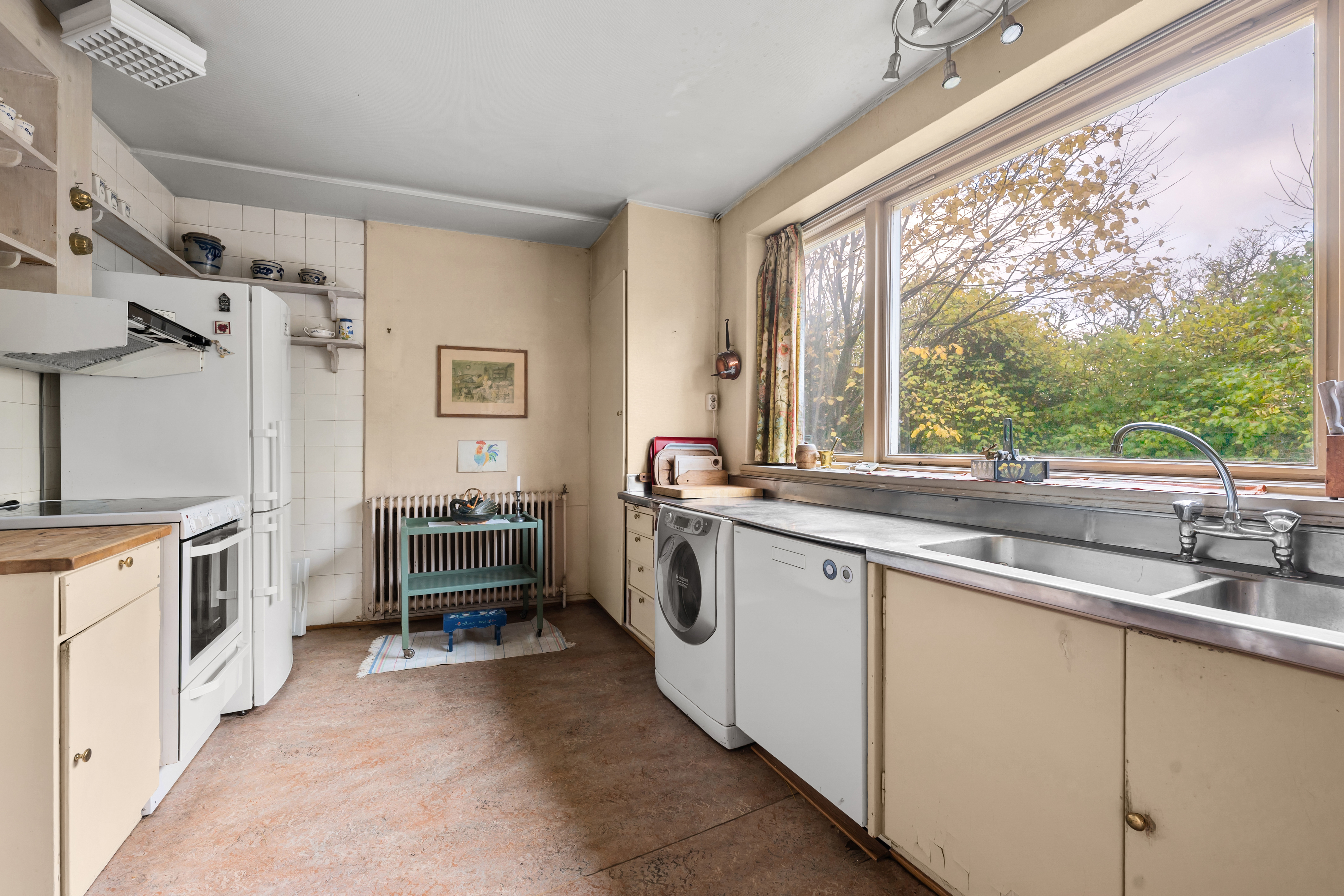 Kjøkkenet har en eldre, plassbygd innredning med glatte skapfronter og benkeplaten er utført i furu.