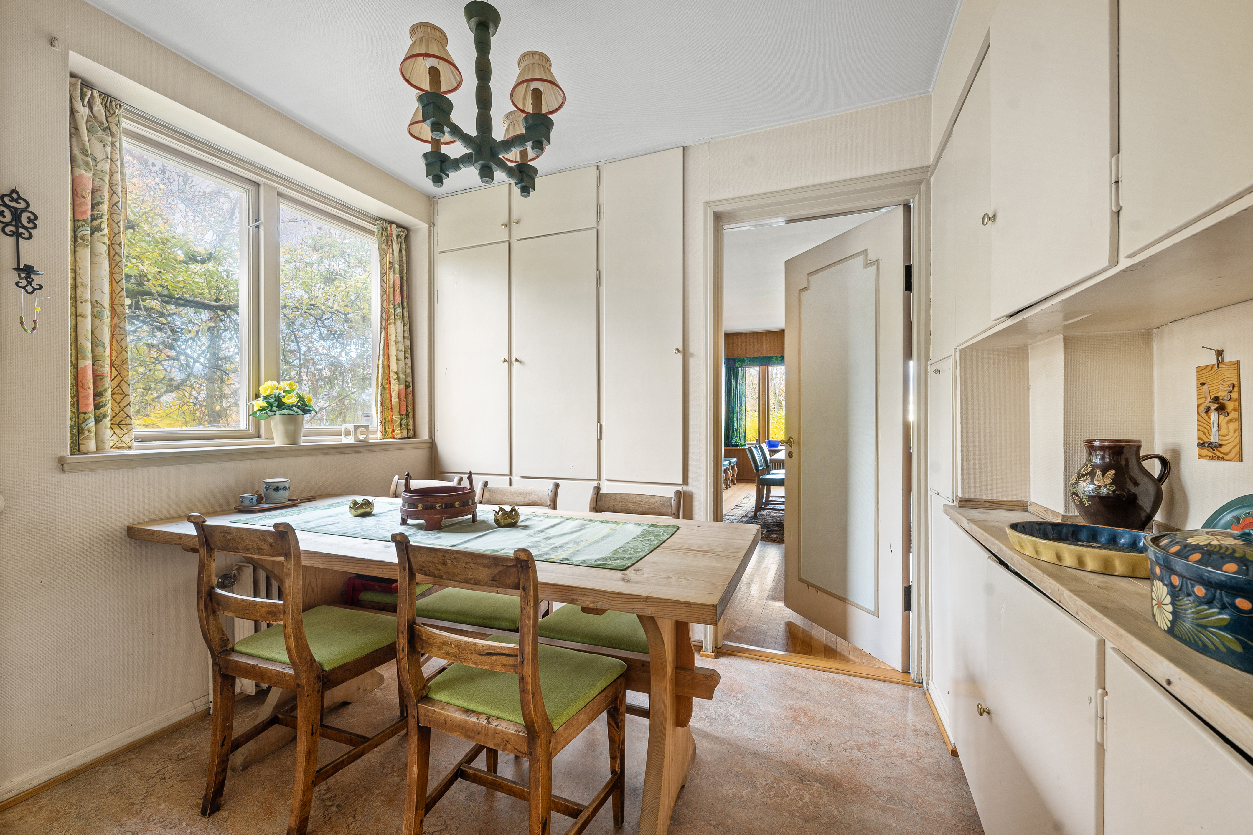 Mellom spisestuen og kjøkkenet, er det montert plassbygde benkeskap og høyskap som gir godt med oppbevaringsplass. Her er det videre god plass til frokostbord. 