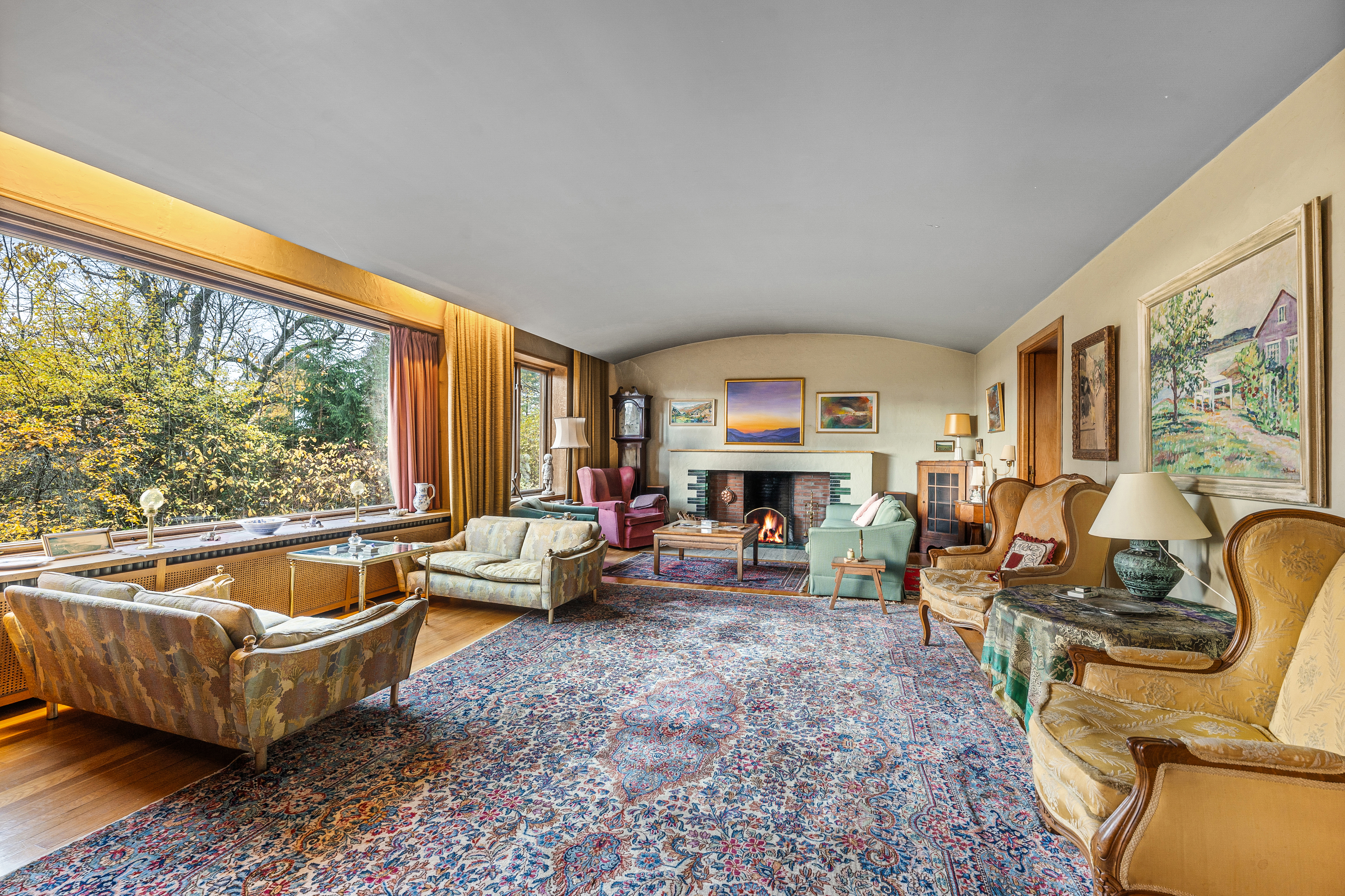 Stuen oppleves som delikat med lyse fargevalg, buet tak og store vindusflater som sørger for rikelig lysinnslipp. 