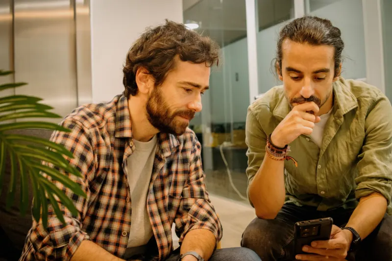 Xavi and Edu reviewing an app on a phone