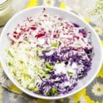 Bord met een kleurrijke koolsalade met dressing.