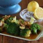 Een portie broccoli in amandel-citroen boter gegarneerd met geschaafde amandelen.