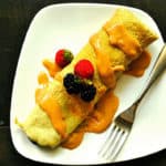 Een heerlijke glutenvrije eiwit pannenkoek met aardbeien en blauwe bessen.