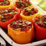Ovenschaal met zes gevulde paprika's met chorizo en ei.
