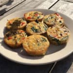 Bord met zes hartige eiermuffins gevuld met ei, spinazie, gehakt, tomaat en nog veel meer!