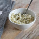 Schaaltje met risotto gemaakt van bloemkoolrijst, mascarpone, groene pesto en geraspte kaas.