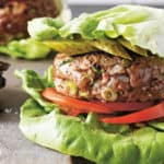 Hamburger geserveerd tussen twee bladeren ijsbergsla.