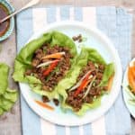 Bord met twee sla wraps gevuld met Aziatisch gehakt.