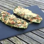 Heerlijke courgette helften gevuld met groenten, tomatensaus en kaas.