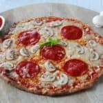 Koolhydraatarme fathead pizza belegd met kaas, salami en champignons.