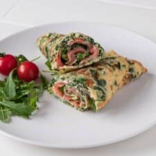 Eiwrap met zalm, spinazie, roomkaas en tomaten.