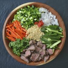 Thaise biefstuksalade met groente en dressing.