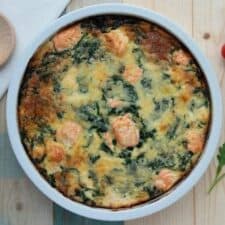 Quiche met zalm, spinazie en geraspte kaas.