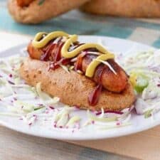 Broodje hotdog met saus en rauwkost.