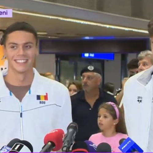 David Popovici, campionul mondial la 100 și 200 de metri liber, a revenit în țară duminică seara și a fost întâmpinat cu aplauze de mulți fani pe aeroportul Otopeni. Sportivul a declarat că este mândru de realizările sale și de echipa sa, menționând că a reușit să se autodepășească în competiția din Singapore. Potrivit digi24.ro, Popovici a respins zvonurile despre posibila sa retragere, afirmând: &quot;Iubesc înnotul în continuare&quot;.