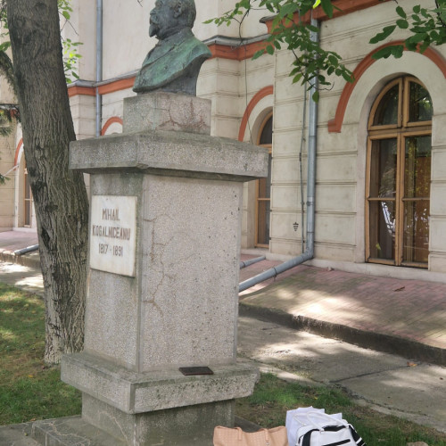 Studente își pun poșetele pe soclul statuii lui Mihai Kogălniceanu la universitate