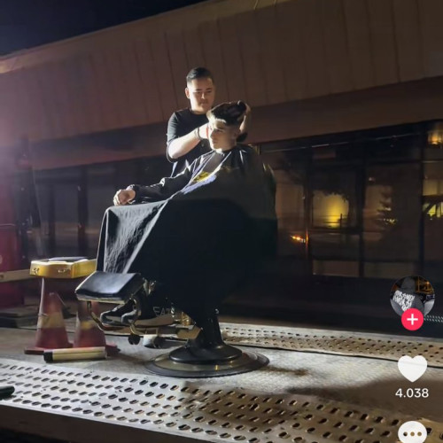 Tânărul din Târgu Jiu tunde în aer liber pe un scaun de frizerie montat pe o platformă auto