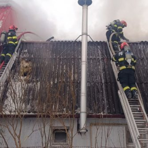 Pompierii din Baia Mare acționează pentru stingerea unui incendiu la o hală de reparații auto