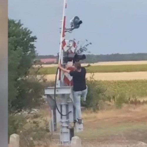 Mecanicul unui tren oprește locomotiva pentru a debloca manual bariera la o trecere la nivel cu calea ferată