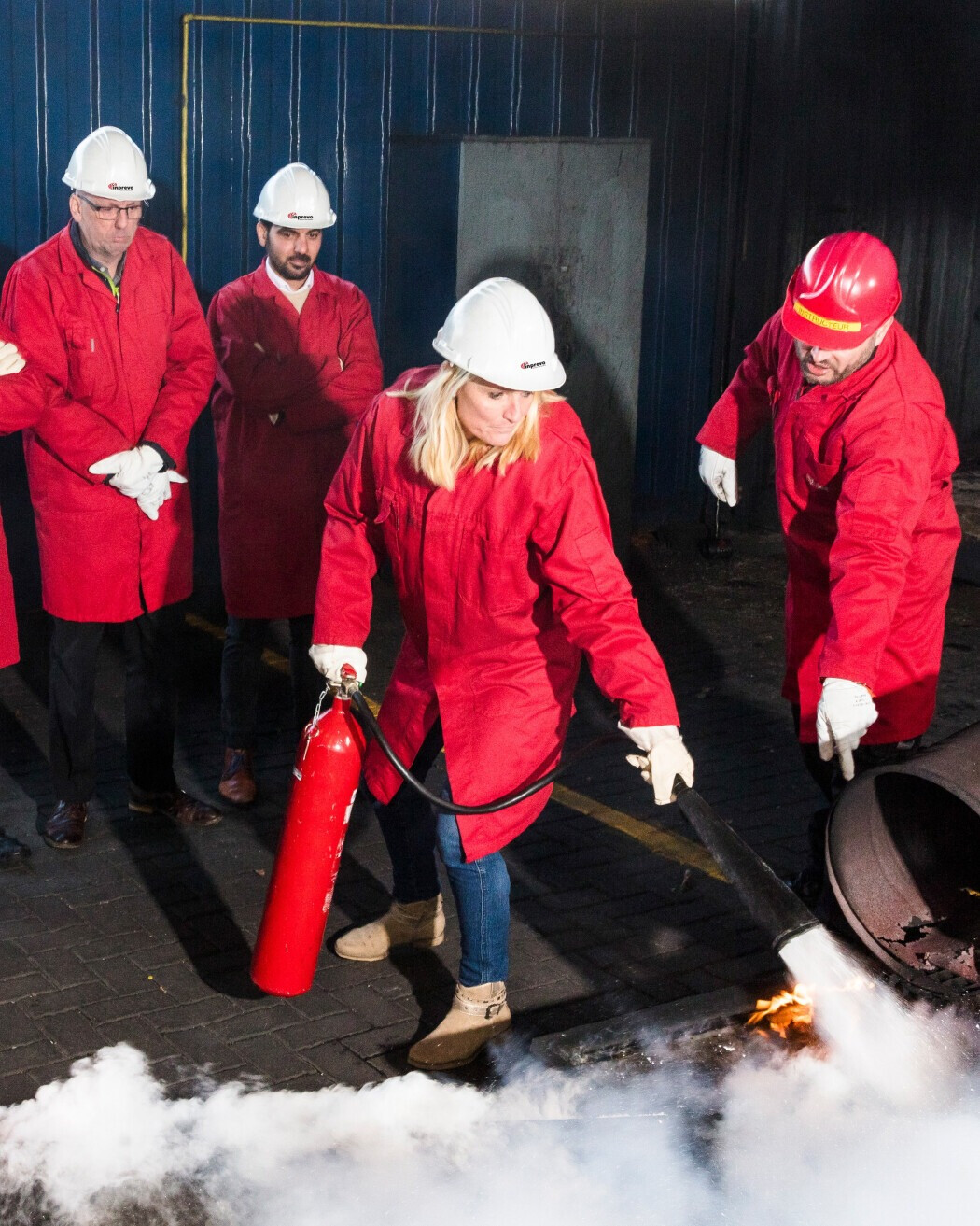 Deelnemer oefent brandbestrijding tijdens een BHV-training voor zakelijke dienstverleners.