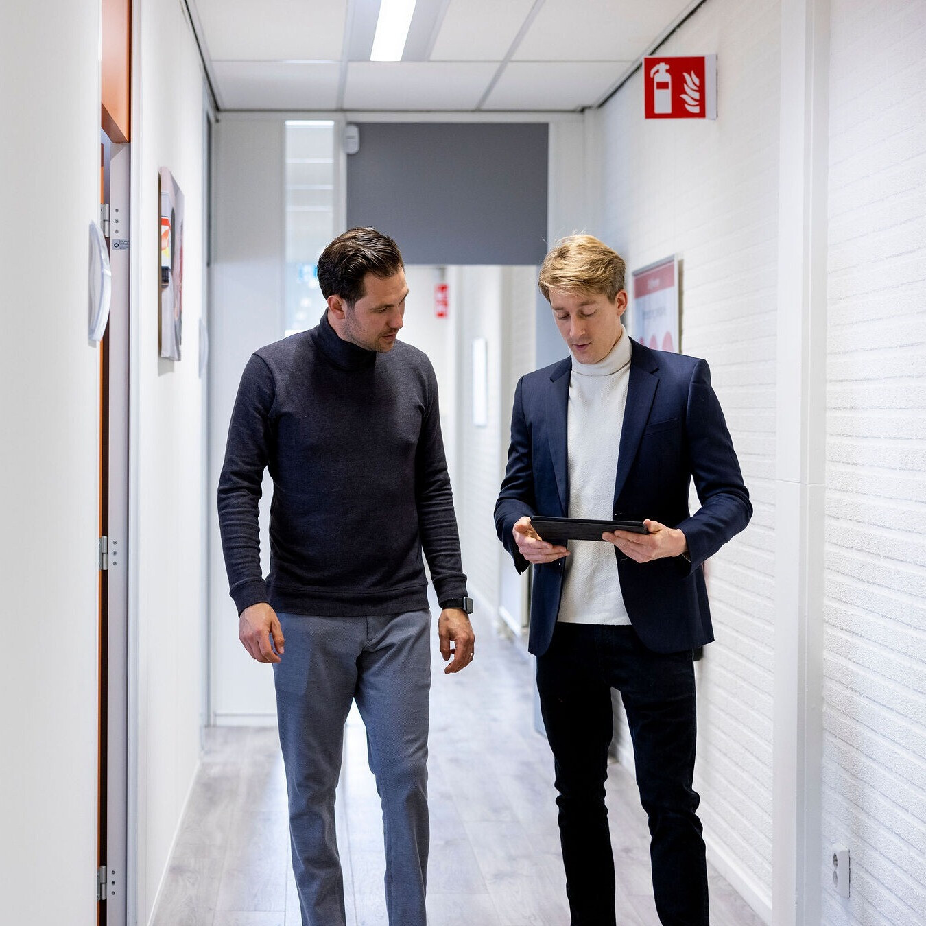 Twee personen bekijken informatie op een tablet in een gebouw