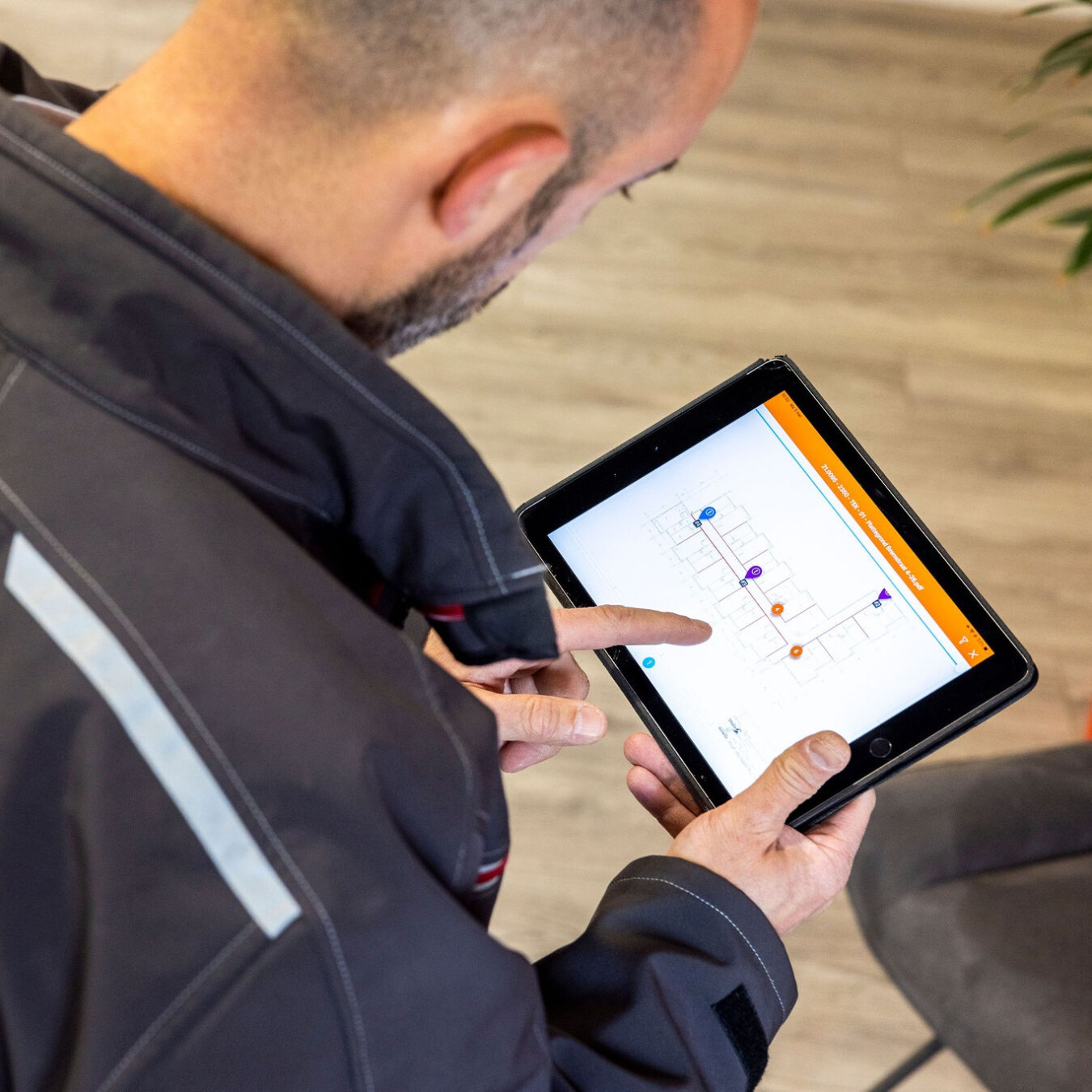 Inprevo-specialist bekijkt een digitale gebouwplattegrond op een tablet