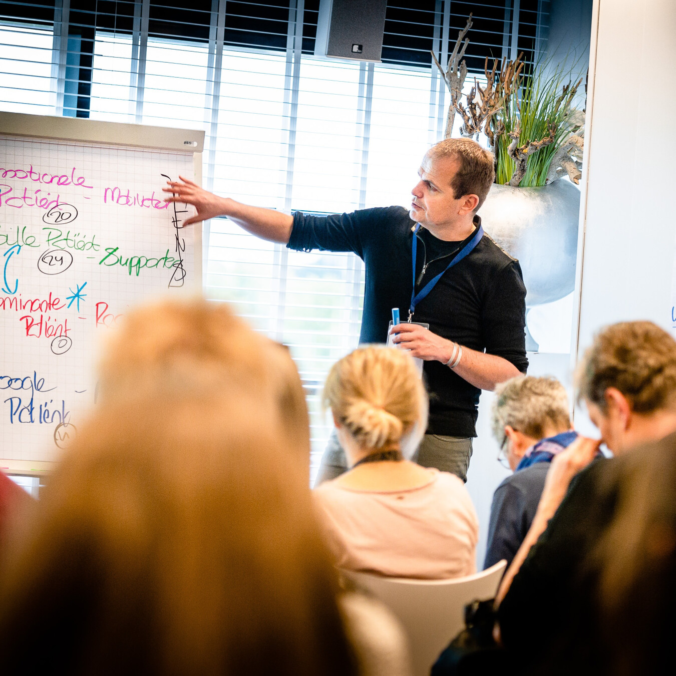 Trainer bespreekt procedures met medewerkers tijdens een veiligheidsoefening