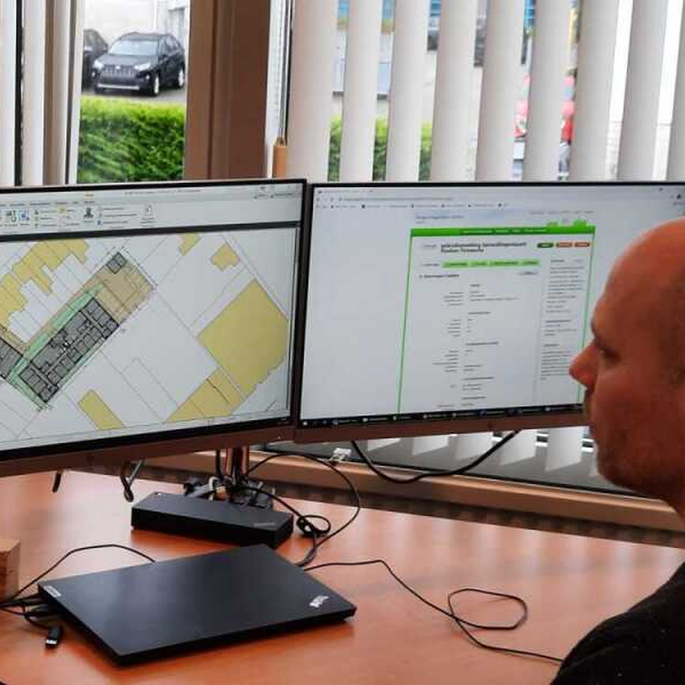Medewerker werkt met een digitale gebouwplattegrond op beeldschermen