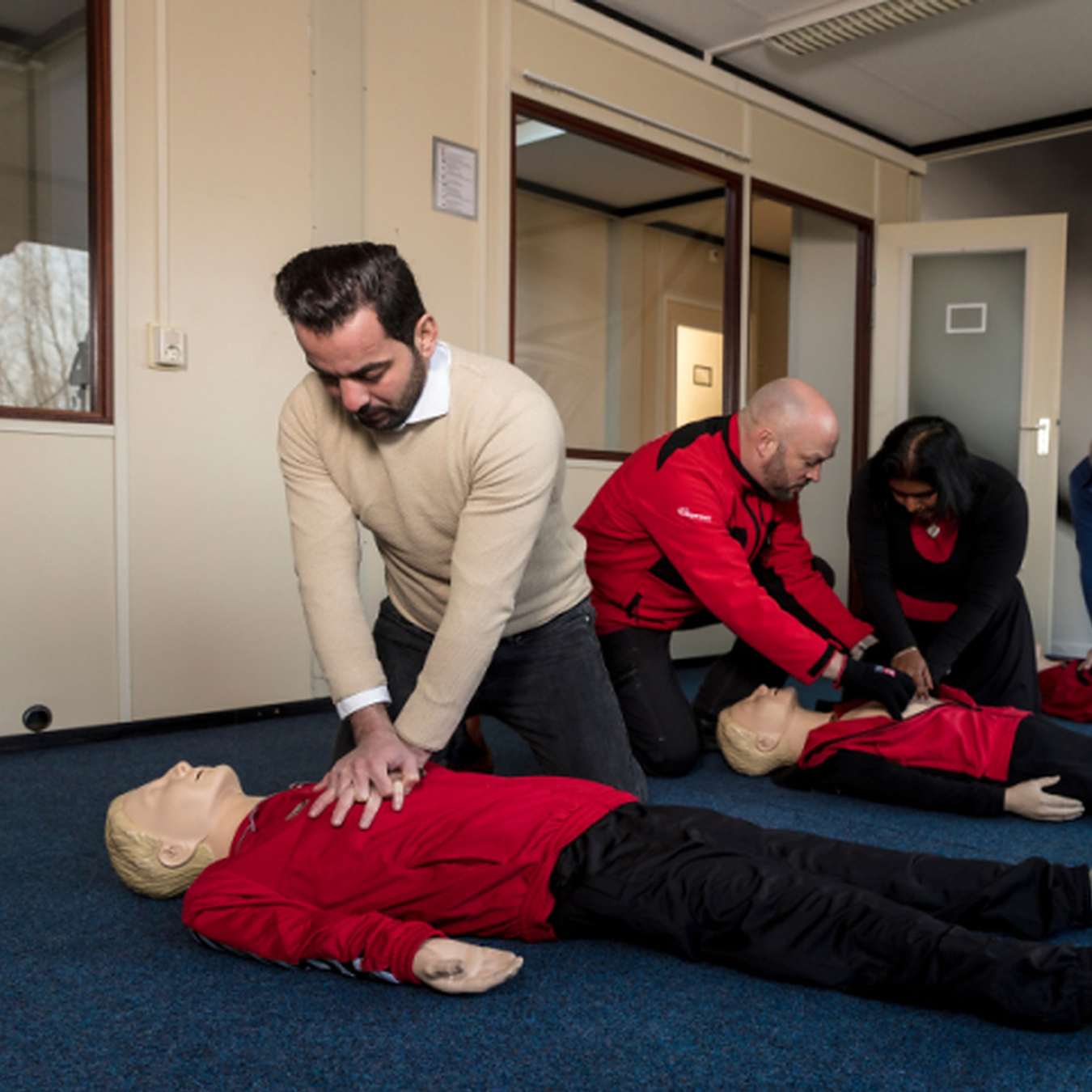 Deelnemers oefenen reanimatie tijdens een praktische BHV-training