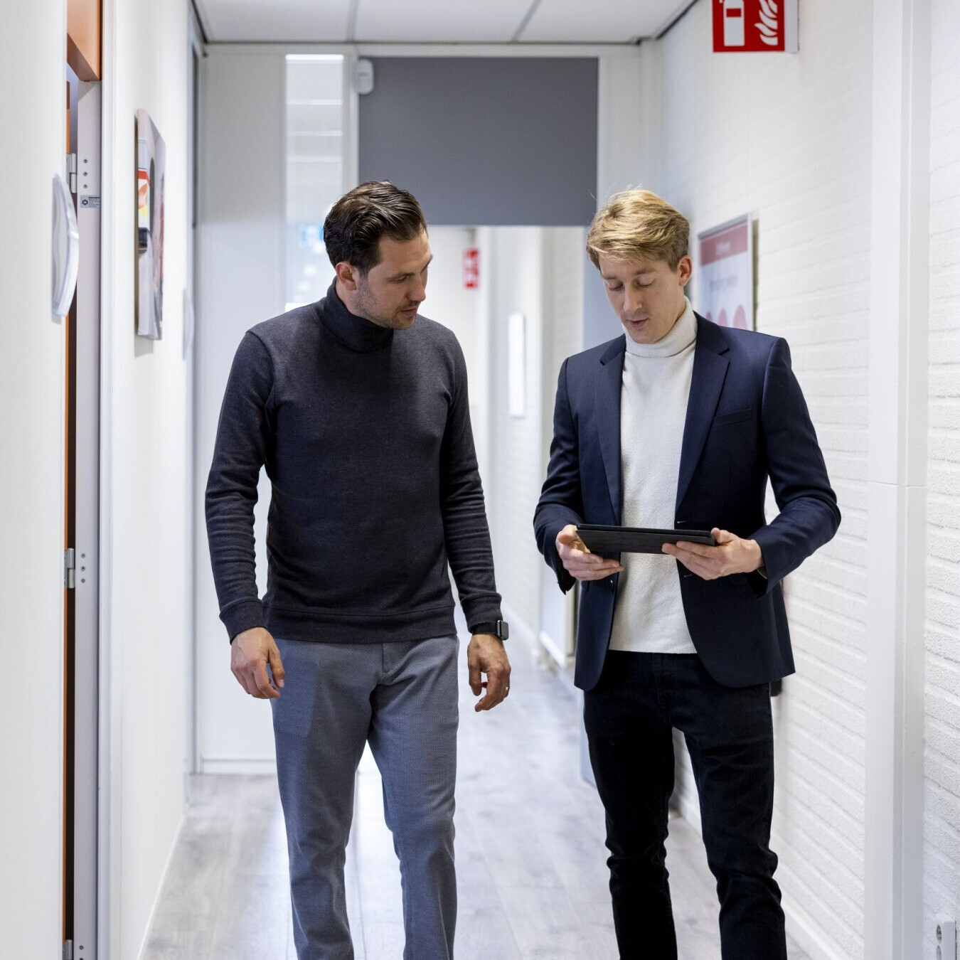 Adviseur bespreekt veiligheidsinformatie met een opdrachtgever in een gebouw