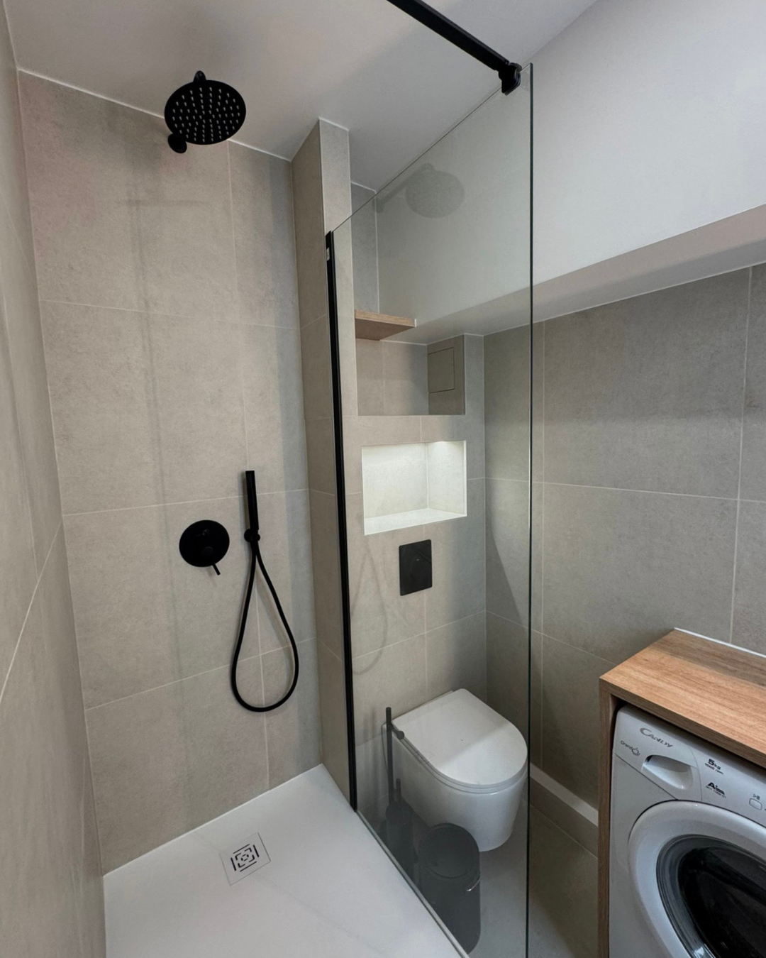 Salle de bain moderne et fonctionnelle avec douche à l’italienne, meuble sur mesure et robinetterie noire