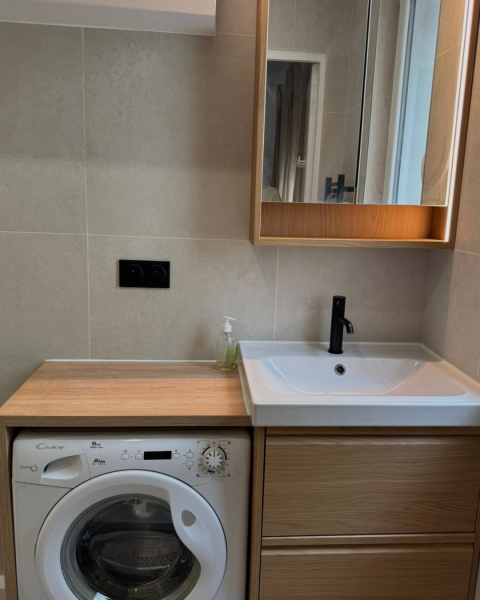Salle de bain moderne et fonctionnelle avec douche à l’italienne, meuble sur mesure et robinetterie noire
